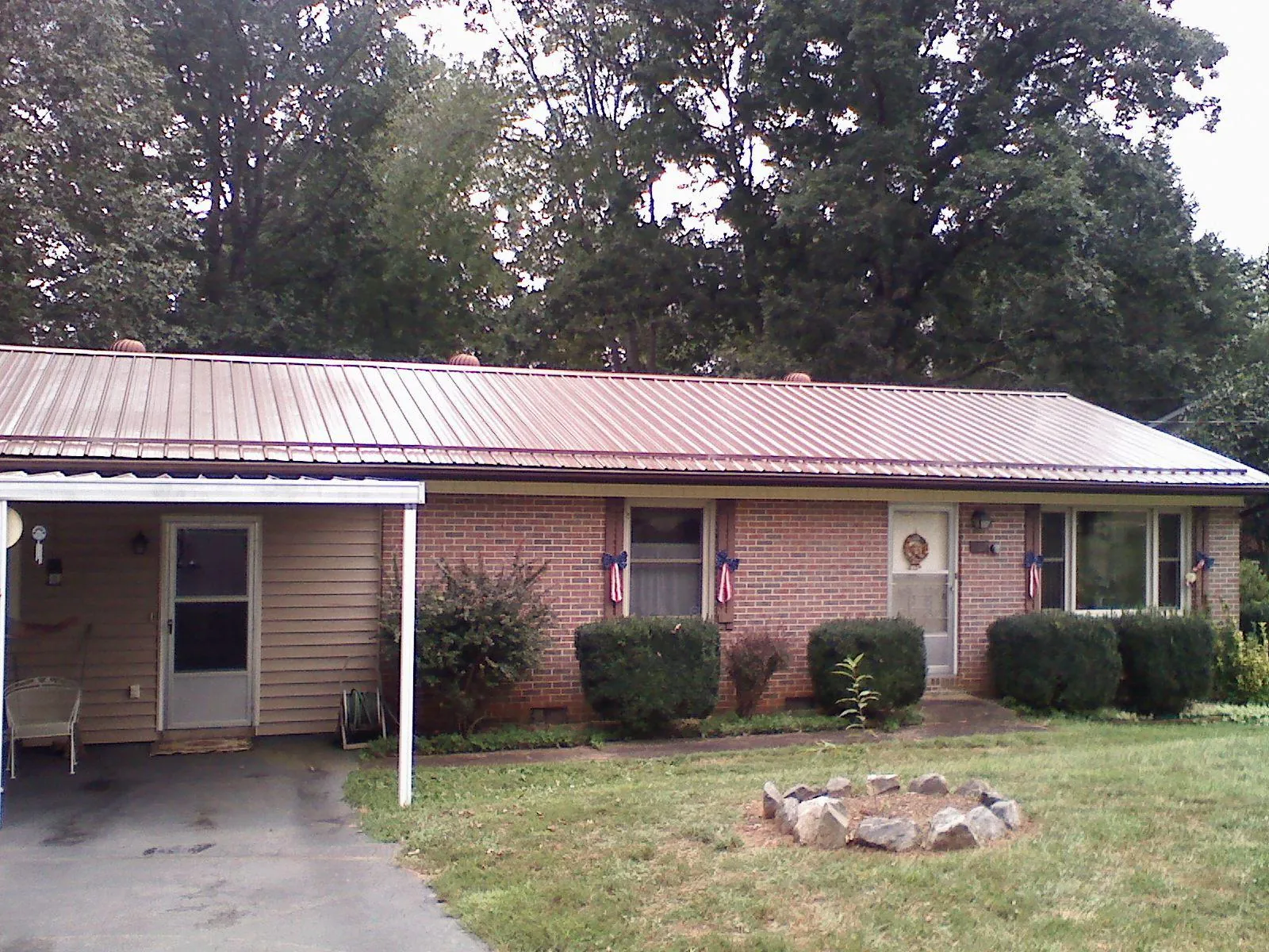 Bronze metal roof and carport on a brick ranch home — Roof Repair work by our crew in Prole